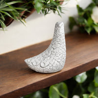 White ceramic bird decor accent with crackled texture placed on wooden table for elegant home decor styling.