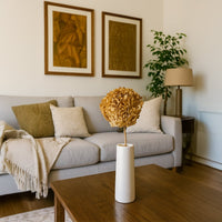 Natural beige dried hydrangea stem held in hand adding warm rustic texture to a cozy modern home decor setting.
