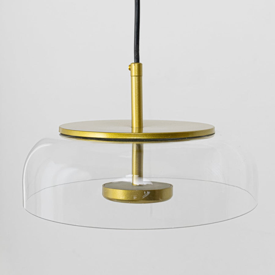 Clear glass and brass metal pendant light with wide shade for elegant dining room decor spaces.