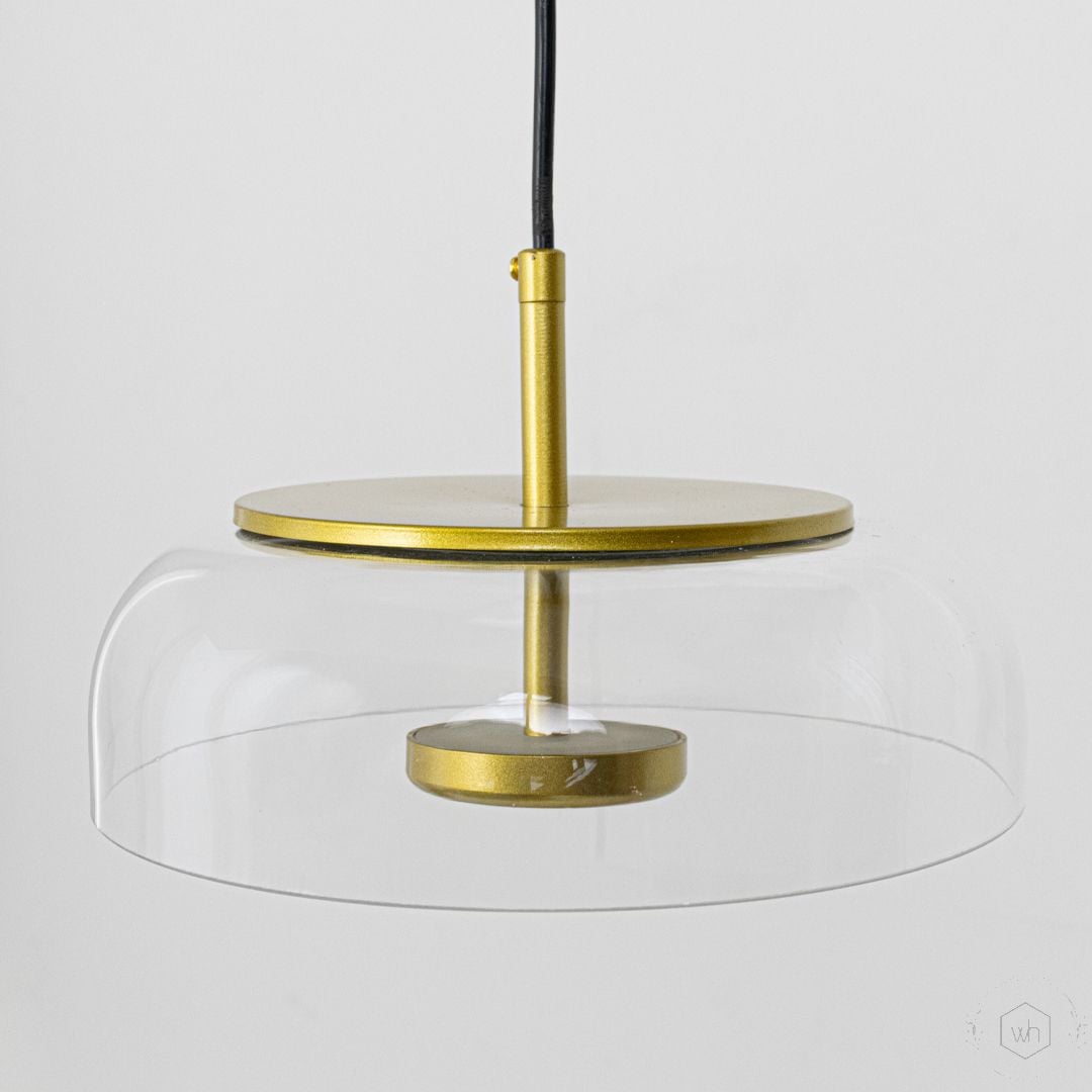 Minimalist clear glass and brass metal pendant light designed for stylish modern home interiors.