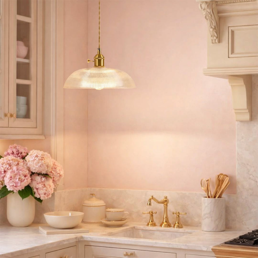 Clear ribbed glass pendant light with gold accents adding warm charm to modern kitchen interiors.