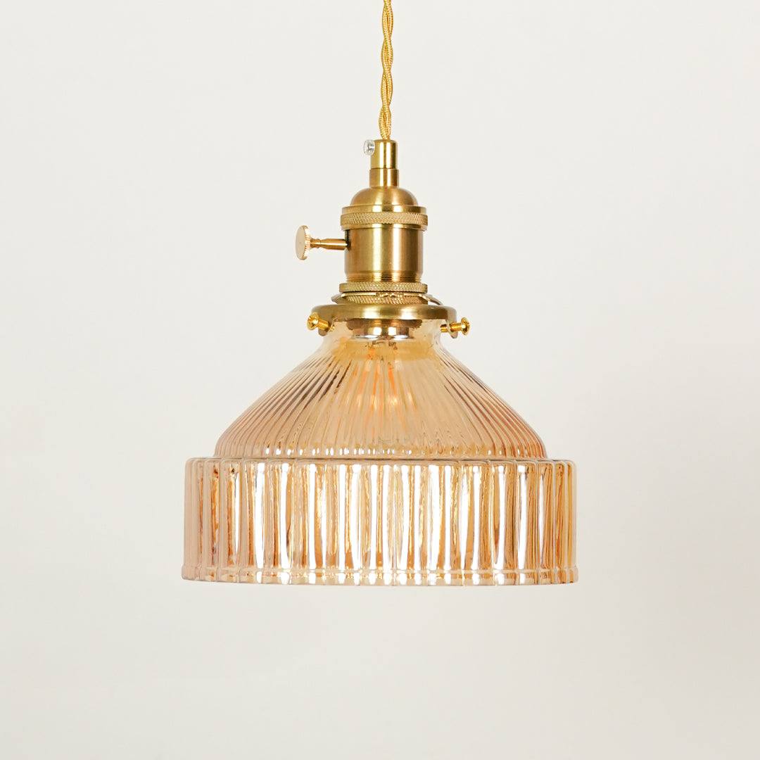 Amber ribbed glass pendant light illuminated to display luxury ceiling lighting with warm ambient decorative appeal.