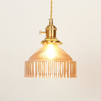Amber ribbed glass pendant light with gold metal fixture illuminated to showcase elegant decorative ceiling lighting.