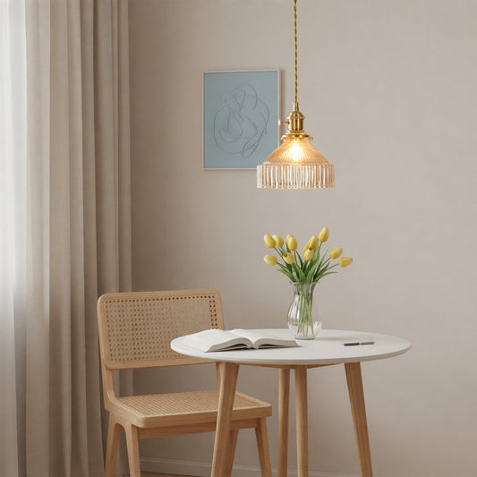 Gold metal pendant light suspended above round dining table adding warm elegance to modern dining room decor.