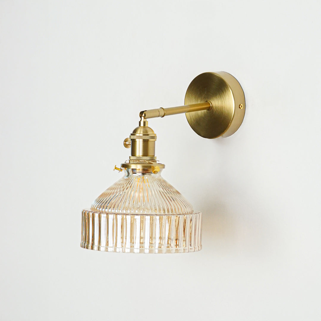 Gold finish wall light with clear ribbed glass shade and classic design perfect for elegant interior wall decor on clean background.