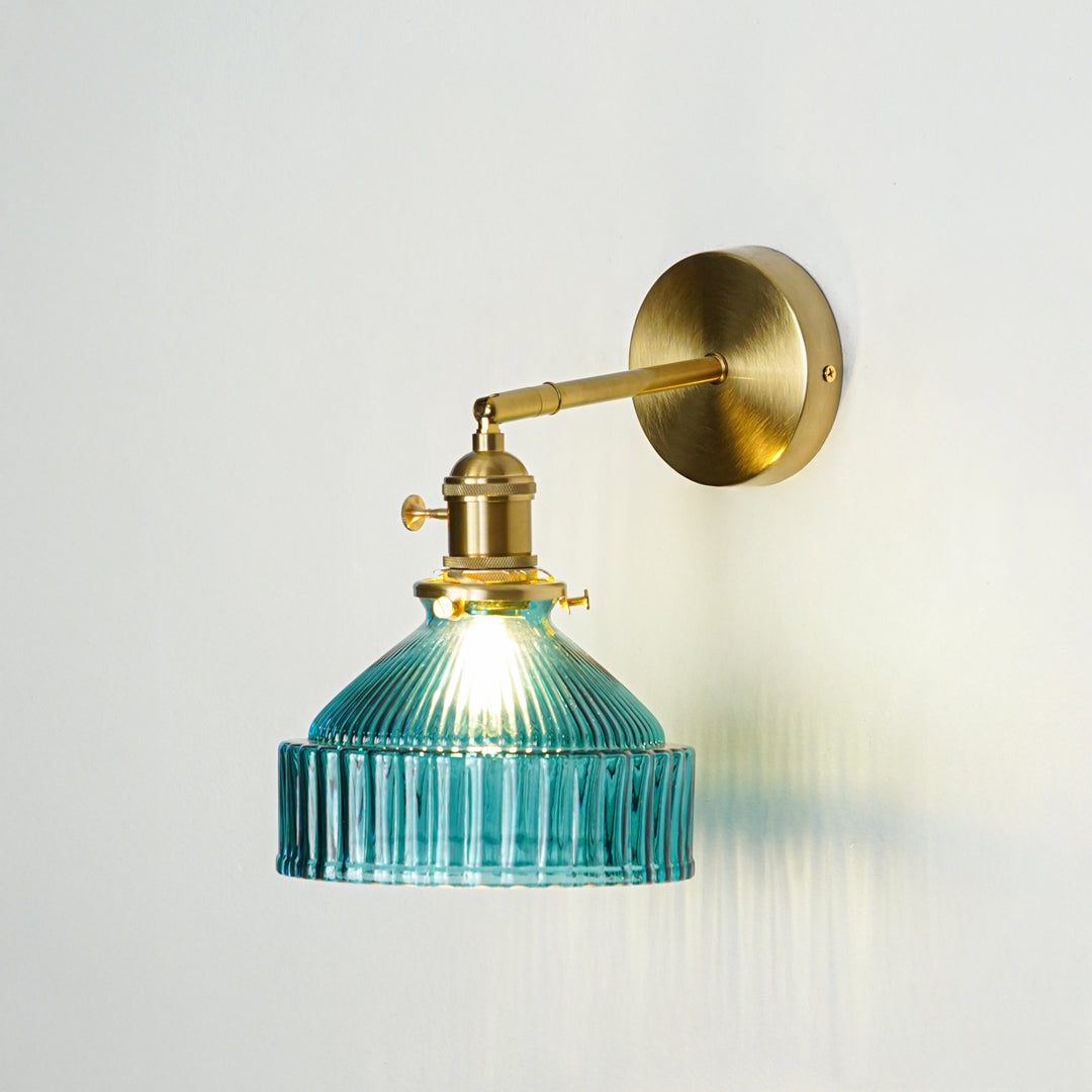 Gold finish wall light with blue ribbed glass shade emitting warm ambient glow ideal for bedroom or hallway wall decor placement.