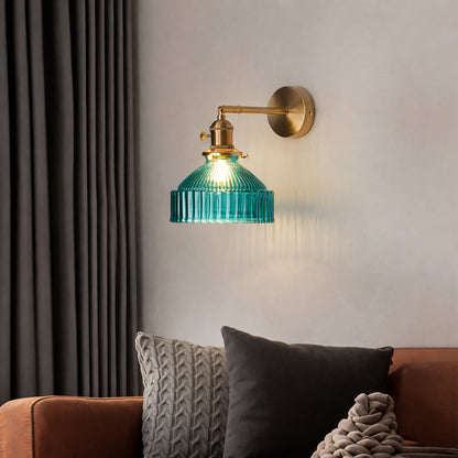 Gold wall light with blue ribbed glass shade casting warm glow styled in modern living space for cozy wall decor ambiance.