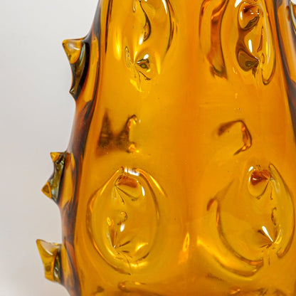 Close up view amber art glass vase showing raised sculpted texture glossy finish decorative glass accent for shelf styling home.