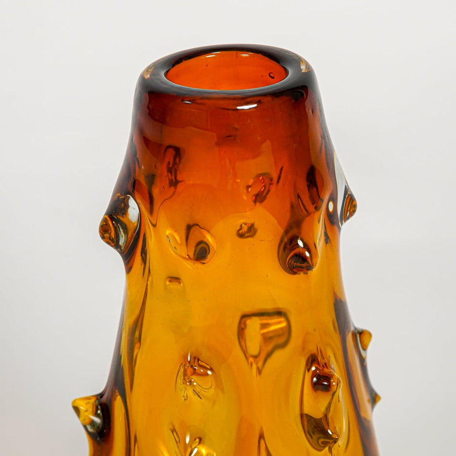 Close up view amber decorative glass vase showing artistic form rich color luxury glass accent piece for console shelf styling.