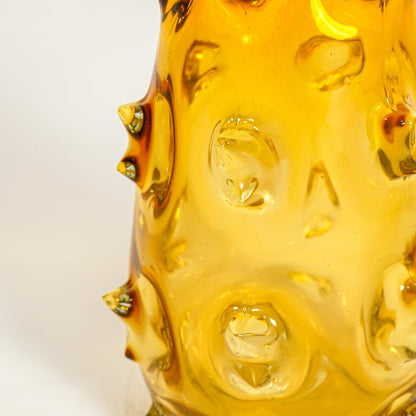 Close up view amber art glass vase showing raised sculpted texture glossy finish decorative glass accent for shelf styling home.