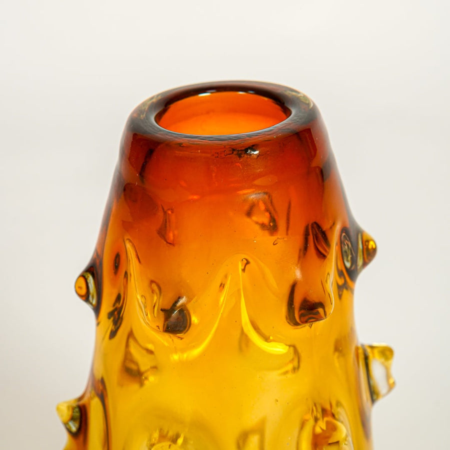 Close up view amber decorative glass vase showing artistic form rich color luxury glass accent piece for console shelf styling.