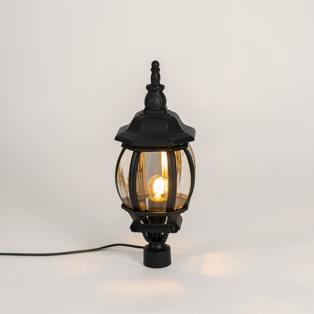 Decorative black outdoor gate light with warm glowing bulb for luxury exterior decor styling use.