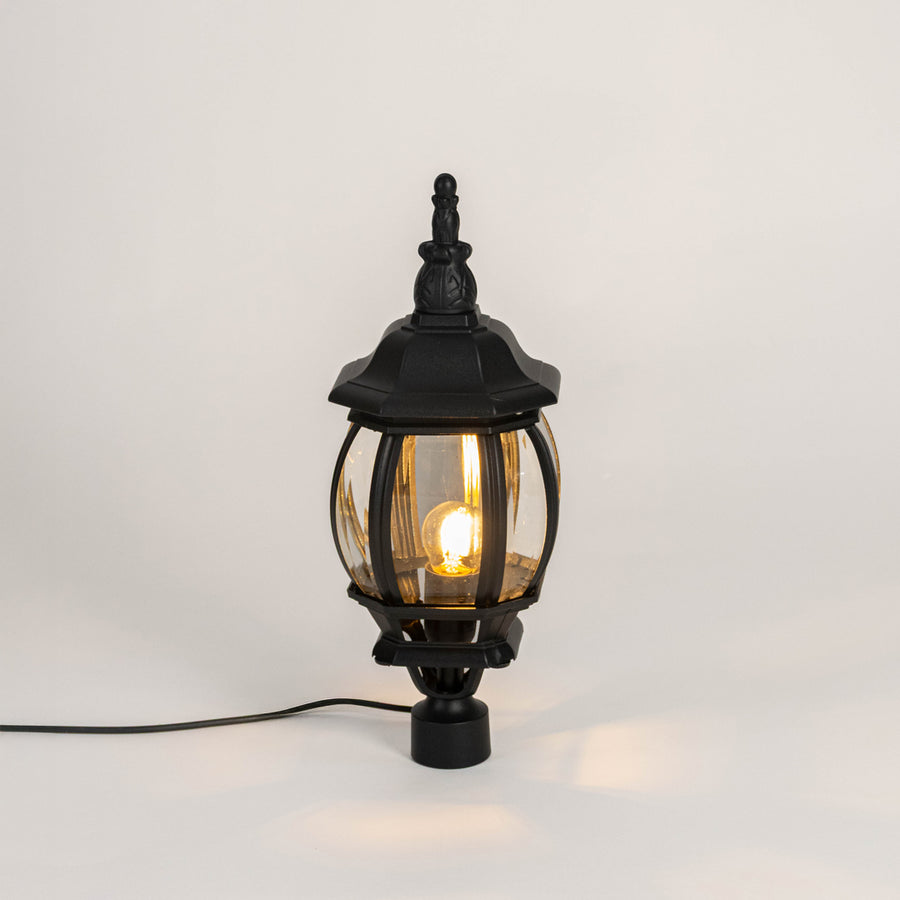 Decorative black outdoor gate light with warm glowing bulb for luxury exterior decor styling use.