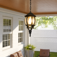 Classic black iron chain hanging globe glass lantern pendant light from wooden porch ceiling for exterior patio styling.