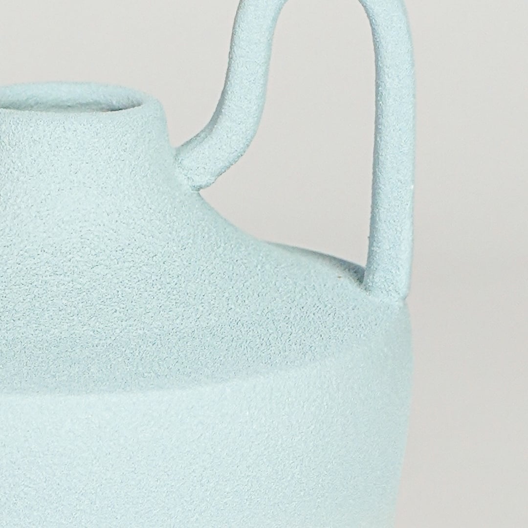 Close view of pastel blue ceramic vase highlighting soft gradient finish sculpted neck and symmetrical handles.