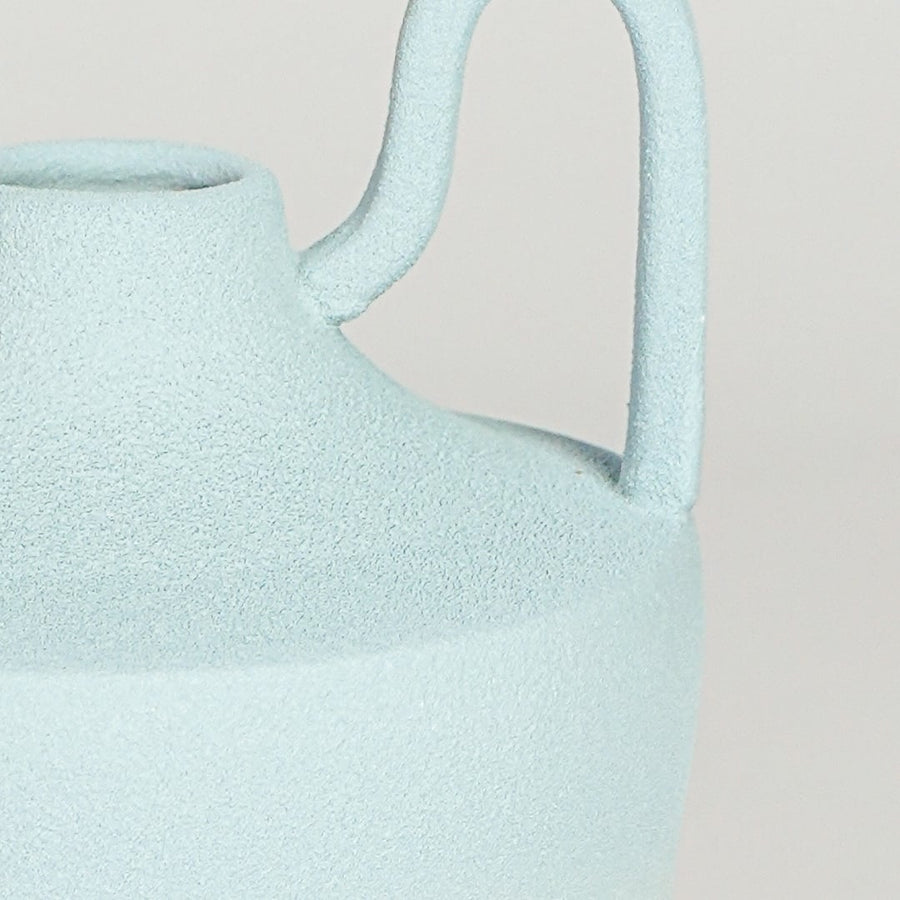 Close view of pastel blue ceramic vase highlighting soft gradient finish sculpted neck and symmetrical handles.