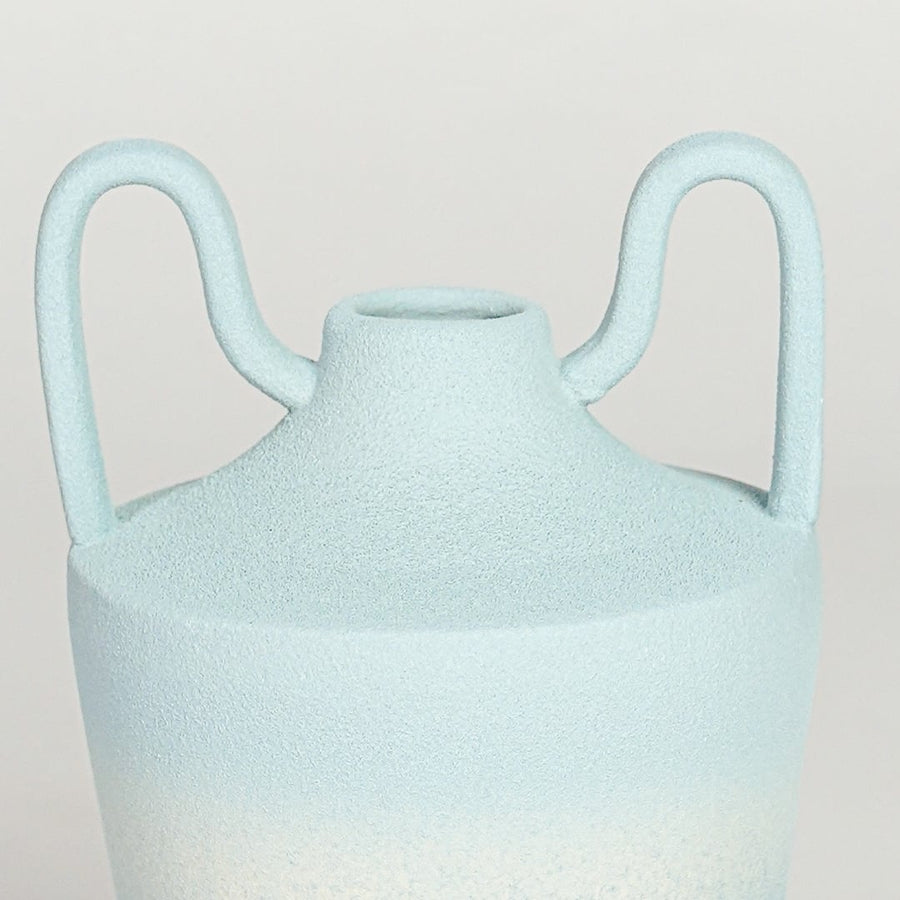 Table lamp style ceramic vase with soft textured finish and sculpted rim detail shown in close up highlighting its organic shape and subtle tonal variation