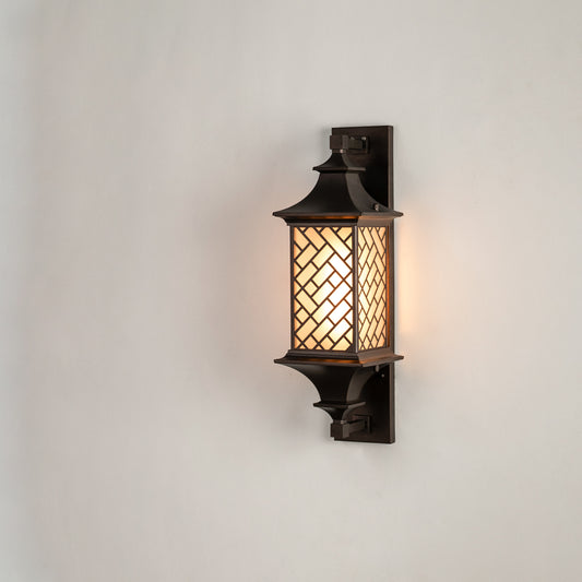 Modern bronze outdoor column wall light on white background featuring an intricate basketweave lattice overlay shade.