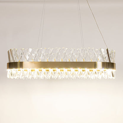Gold metal chandelier with clear crystal rods shown with lights on against a white background highlighting its glowing sophisticated illumination.