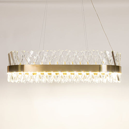 Gold metal chandelier with clear crystal rods shown with lights on against a white background highlighting its glowing sophisticated illumination.