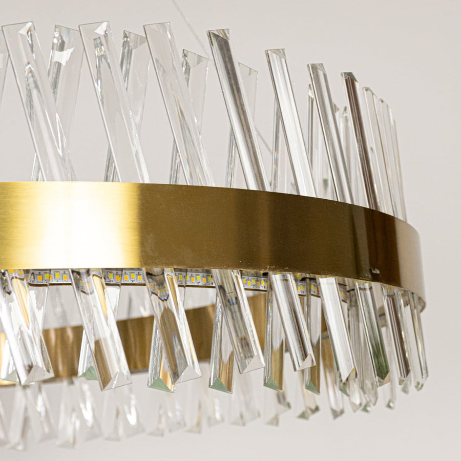 Closeup of gold metal chandelier highlighting the faceted crystal rods and polished gold ring frame designed for premium elegant interior lighting.