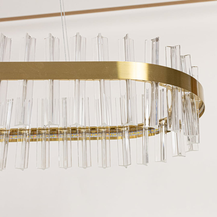 Closeup of gold metal chandelier highlighting the clear crystal rod detailing and elegant metallic frame crafted for luxurious modern lighting.