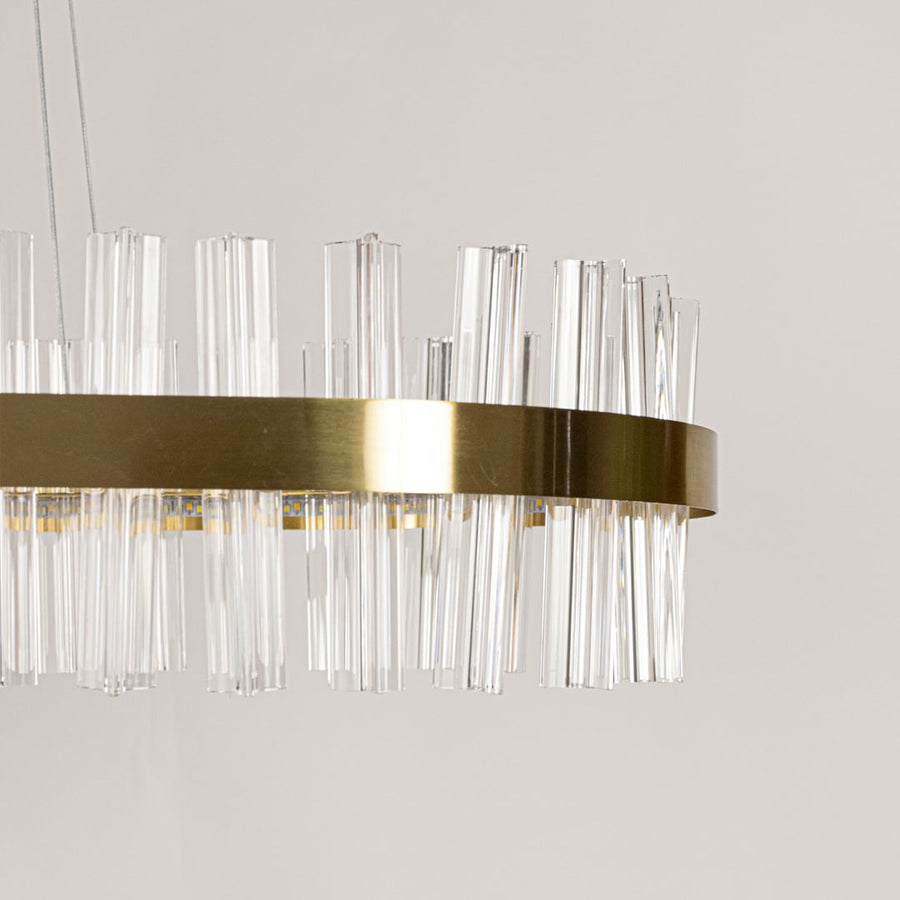 Closeup shot of gold metal chandelier focusing on its crystal textures and warm illumination for refined and elegant interior lighting.
