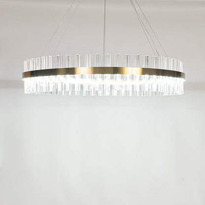 Gold metal chandelier with clear crystal rods displayed with lights lit on a clean white background showcasing its modern circular design.
