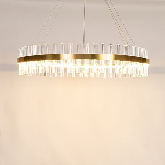 Gold metal chandelier with crystal rods shown with lights on creating a warm elegant and sparkling lighting effect.