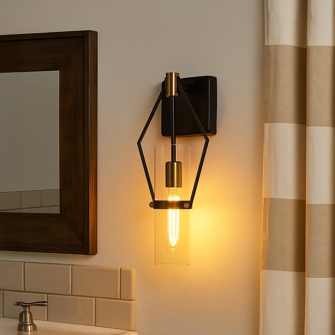 Modern black metal wall sconce with gold accents and clear glass shade adding warm ambient lighting to a stylish interior.