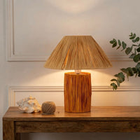 Rustic wood table lamp with pleated rattan shade on wooden console table for farmhouse bedroom interior home decor styling.
