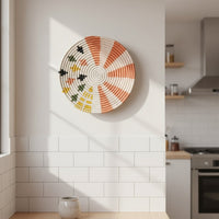 Handcrafted round wall decor with multicolor pattern mounted on tiled kitchen wall adding artistic charm and vibrant accent to modern interior.