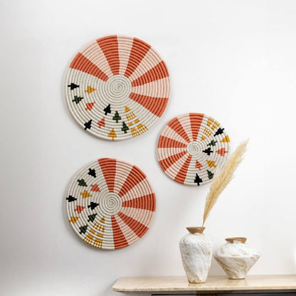 Handcrafted seagrass wall basket set with coral orange cream and black pattern for boho living room wall décor styling.