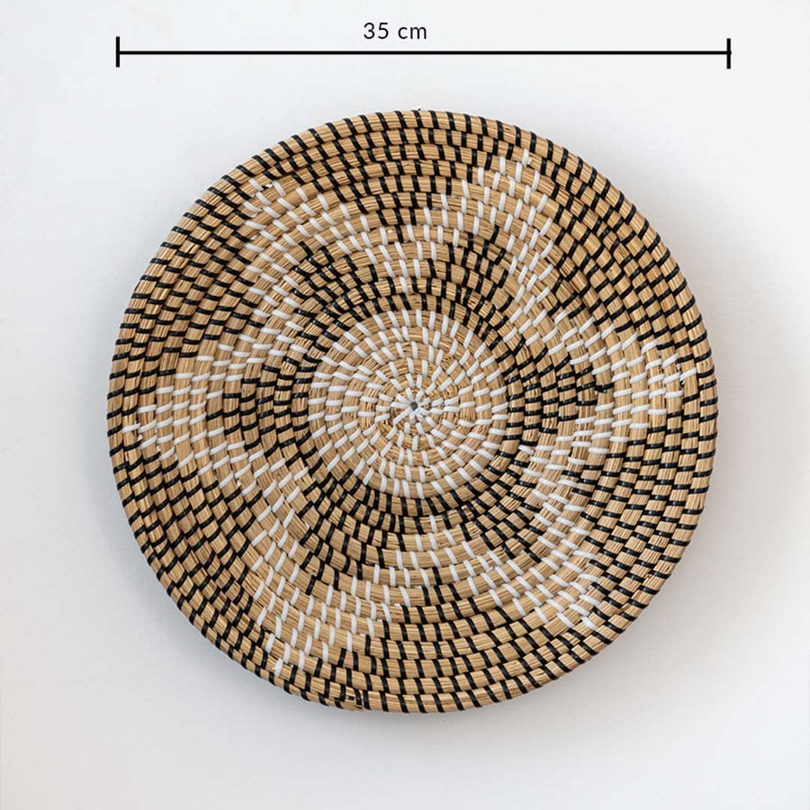 Handwoven wicker basket wall decor in beige with black and white starburst design showing 35 cm size measurement.