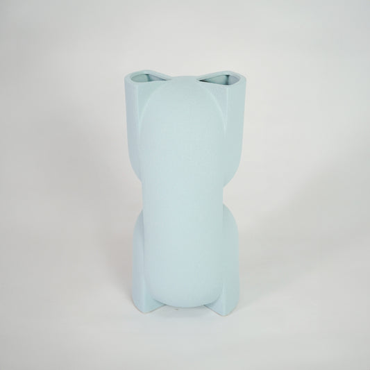 Light blue ceramic vase for modern shelf placement and elegant indoor home decor styling accent piece.