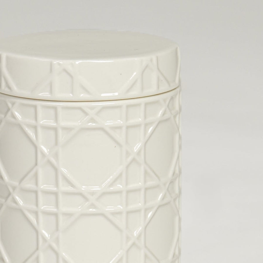 Close view of white ceramic decorative jar featuring geometric embossed pattern and refined glossy finish.