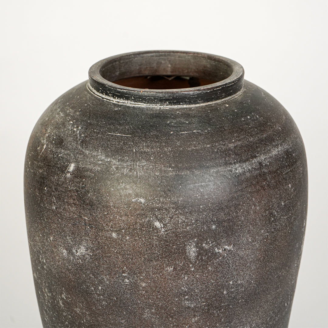 Closeup image of grey ceramic decorative vase for modern tabletop decor styling with textured matte finish.