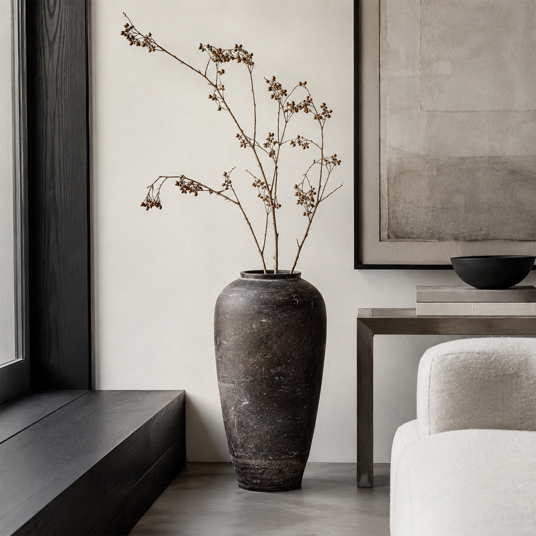 Dark brown textured floor vase placed beside chair for elegant modern home decor styling.