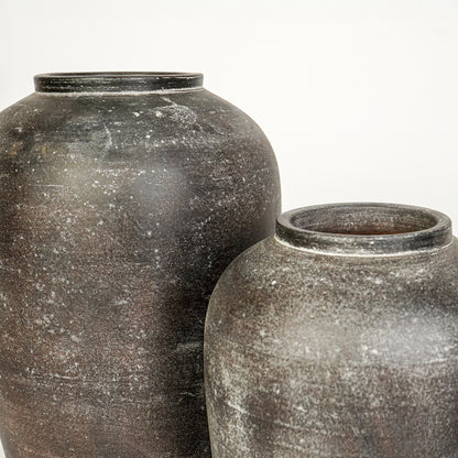 Closeup image of grey ceramic decorative vase set for modern interior styling with textured matte finish.