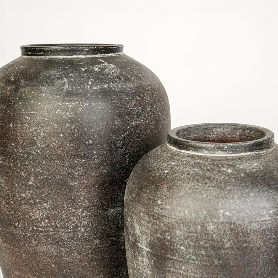 Closeup image of grey ceramic decorative vase set for modern interior styling with textured matte finish.