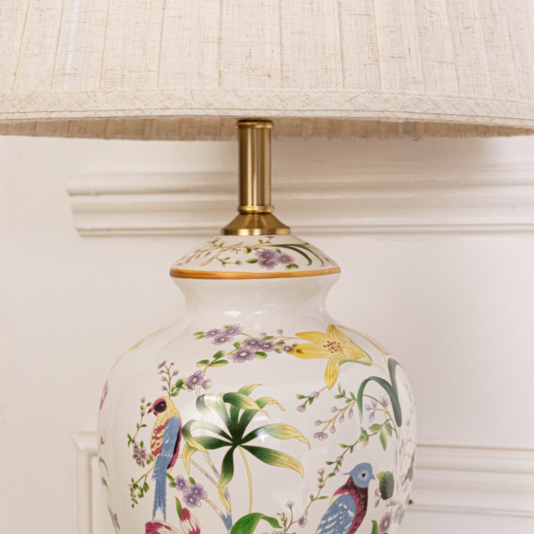 Close view of ceramic table lamp showcasing floral art and golden detailing reflecting premium craftsmanship and sophisticated design appeal.