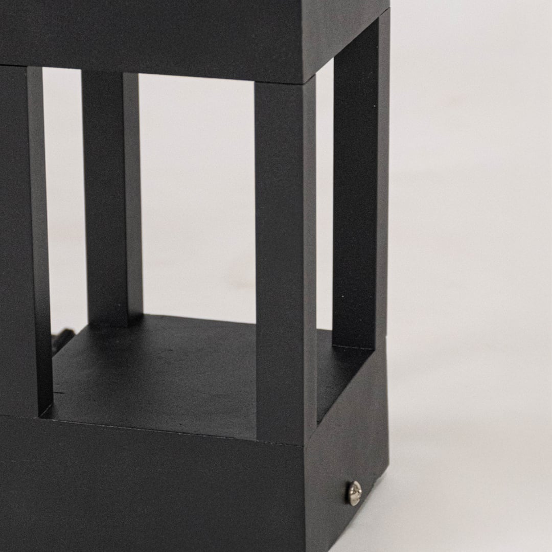 Closeup showing matte black metal texture and sleek open rectangular design of modern pillar light.