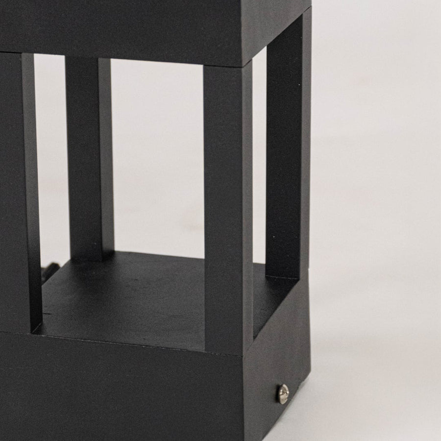 Closeup showing matte black metal texture and sleek open rectangular design of modern pillar light.