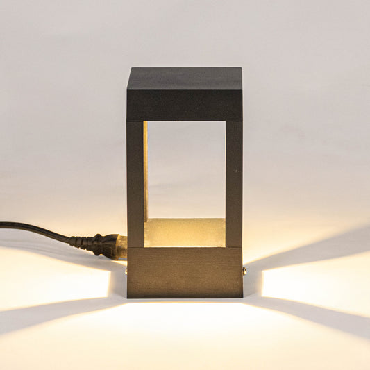Modern black outdoor wall light with warm glowing panels for elegant exterior decor styling use.