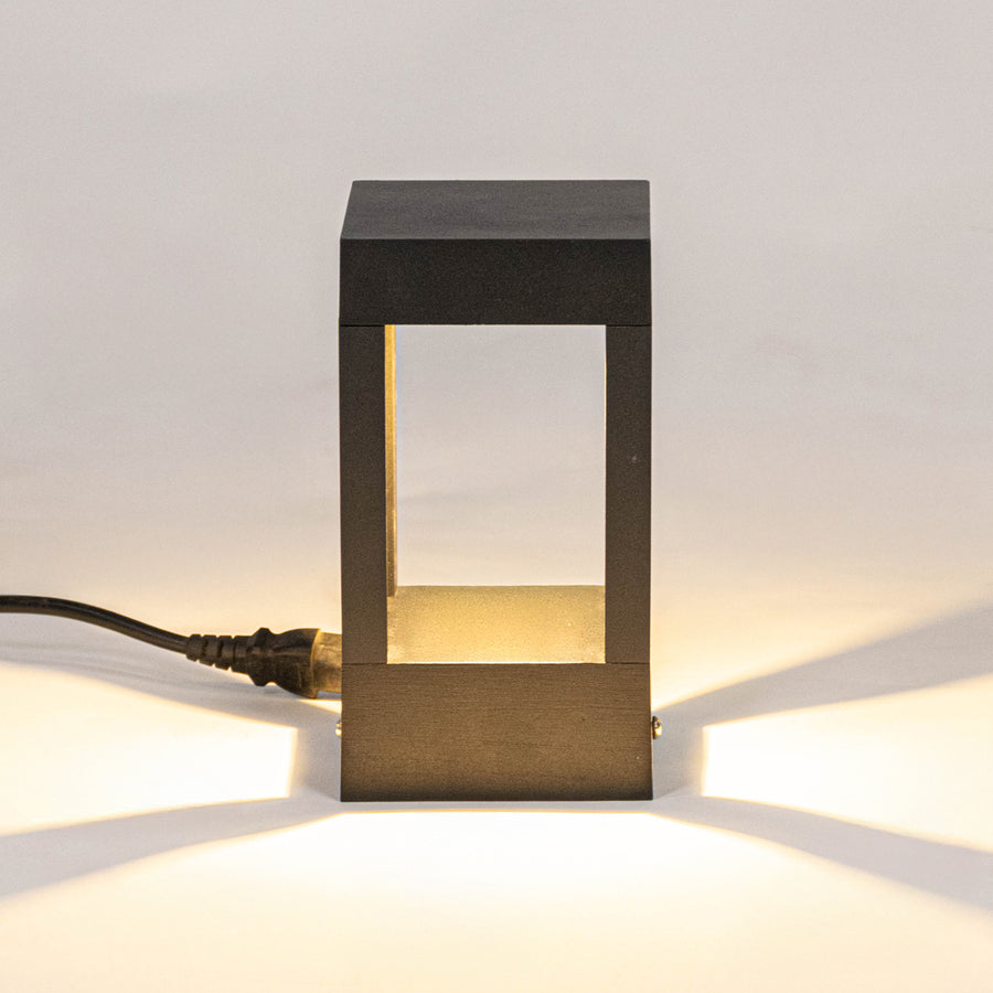 Modern black outdoor wall light with warm glowing panels for elegant exterior decor styling use.