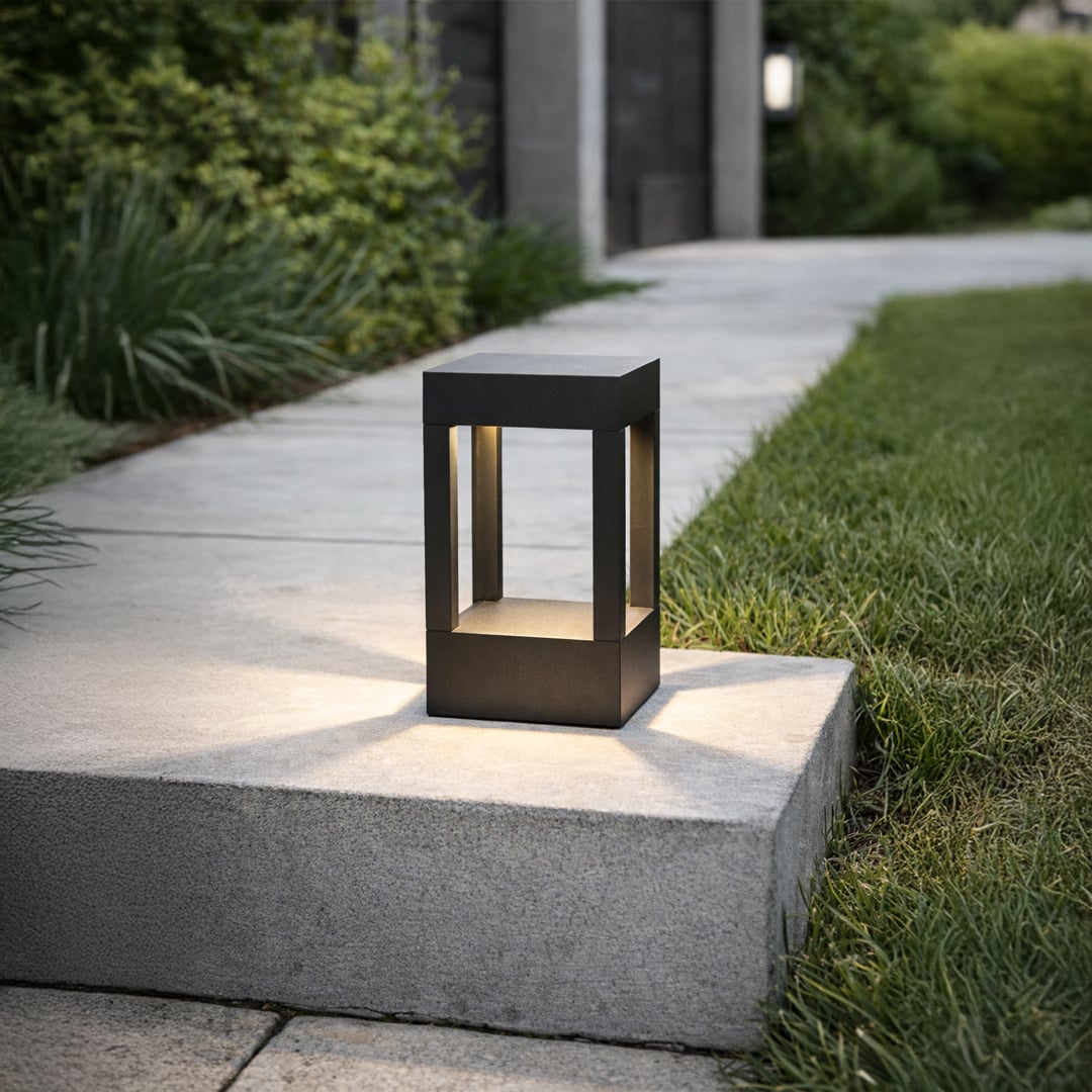 Black metal outdoor lantern light placed on concrete step for elegant exterior lighting decor styling ideas.