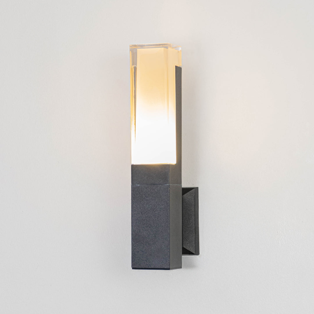 Black metal wall light on white background with frosted glass shade for minimalist modern decor.