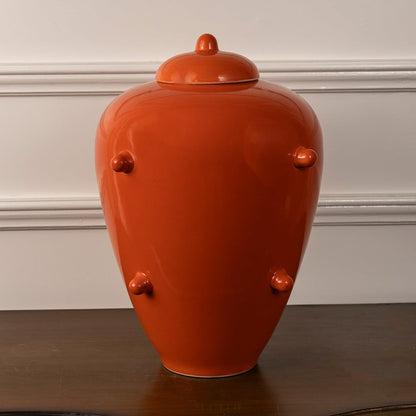 Vibrant orange ceramic ginger jar with lid and decorative knobs for stylish modern home and living room decor.