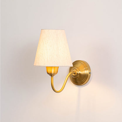 Illuminated brass wall lamp with glowing white shade and elegant curved bracket on clean white background display view.
