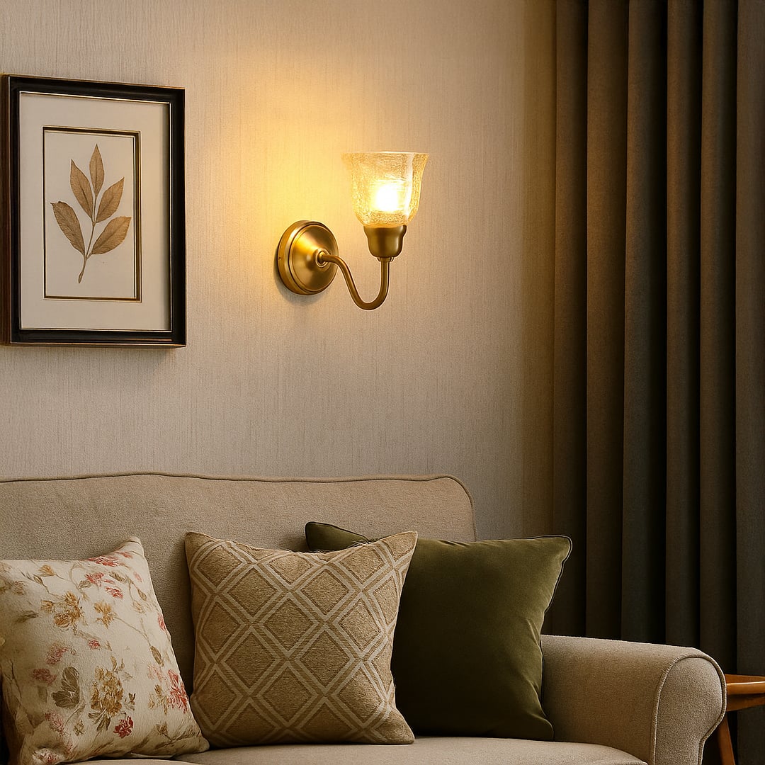 Vintage brass wall sconce with amber crackle glass shade and curved arm mounted on wall creating warm rustic lighting.